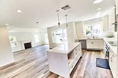 Renovated kitchen with white waterfall quartz island